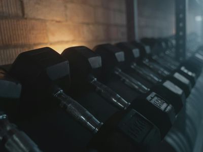 Row of iron dumbbells on a metallic rack.